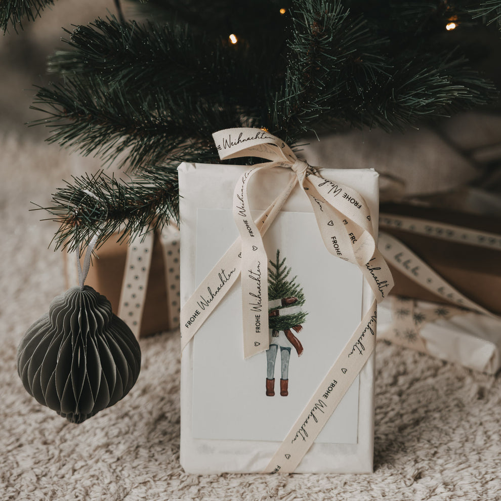 Weihnachtsgeschenk mit beigem Geschenkband Frohe Weihnachten von Eulenschnitt unter dem Weihnachtsbaum