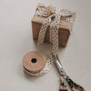 Beiges Geschenkband mit schwarzen Sternen, Geschenk, Rolle und Schere
