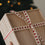 Holzbox mit beigem Geschenkband und roten Herzen vor einem Weihnachtsbaum