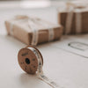 Geschenkband mit Nussknacker-Motiv auf Rolle vor weihnachtlich verpackten Geschenken