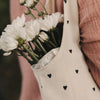 Detailansicht der Baumwolltasche mit schwarzem Herzmuster und weißen Blumen