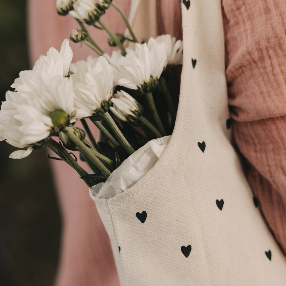 Detailansicht der Baumwolltasche mit schwarzem Herzmuster und weißen Blumen