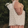 Große faltbare Baumwolltasche mit schwarzen Herzen über der Schulter getragen und mit Blumen gefüllt
