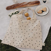 Faltbare Baumwolltasche mit Herzmuster beim Picknick mit Blumen, Zitronen und Baguette