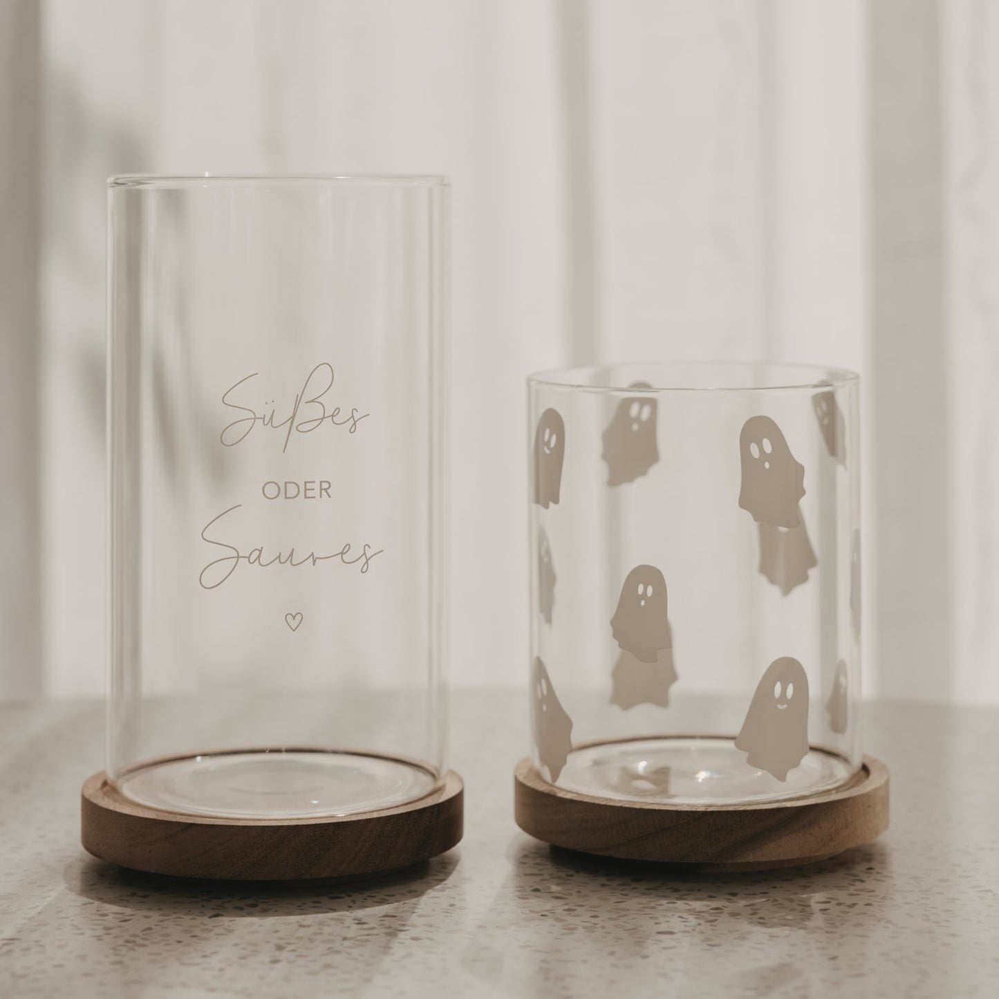 Vorratsglas mit weißen Geistern neben Glas „Süßes oder Saures“, beide mit Holzdeckel