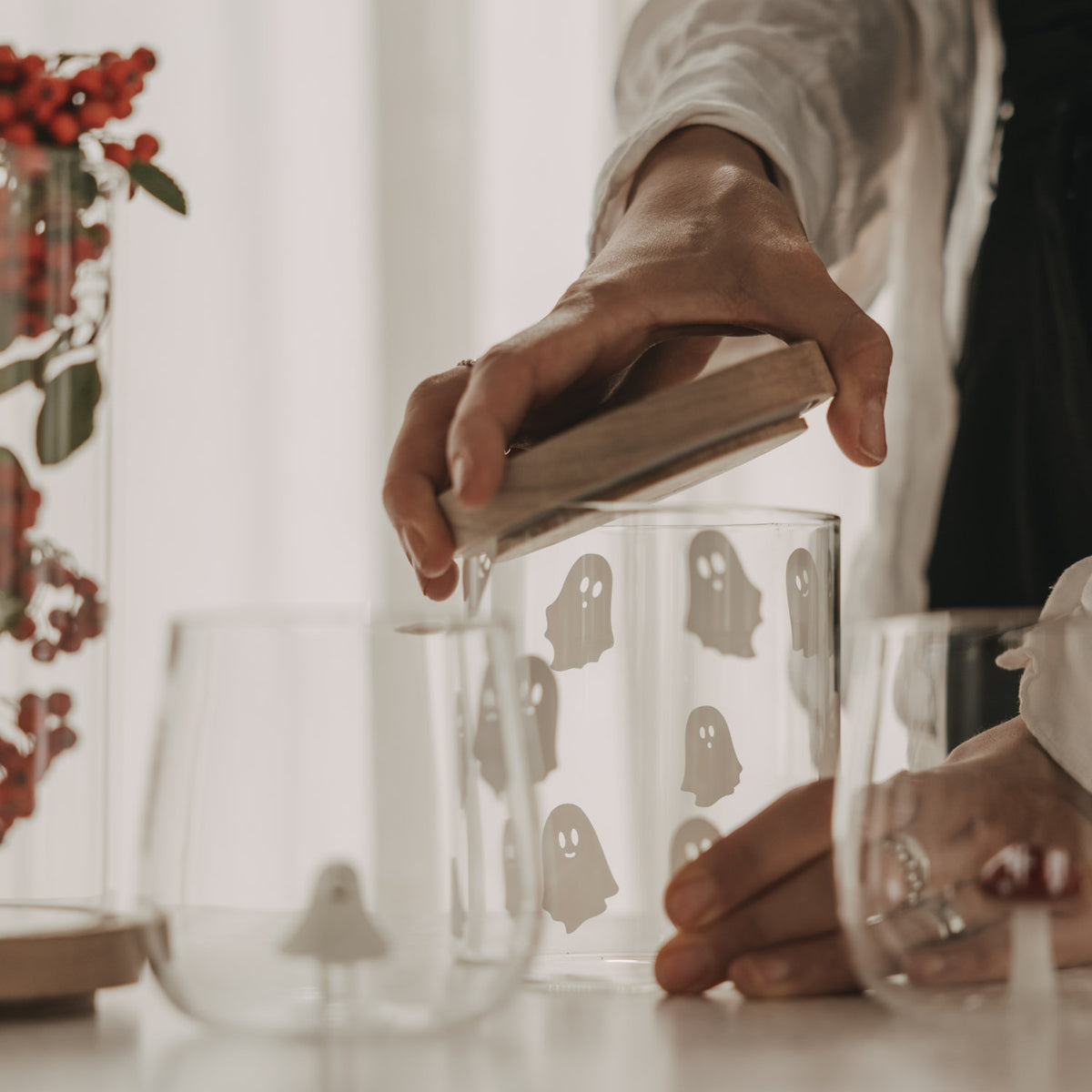 Vorratsglas mit weißen Geistermotiven beim Aufsetzen des Holzdeckels