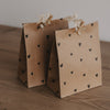 Zwei braune Geschenktüten aus Papier mit kleinen schwarzen Herzen, liebevoll dekoriert mit Holzklammern
