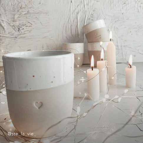 Becher Herz Nahaufnahme, mit Lichterkette und Kerzen dekoriert. 