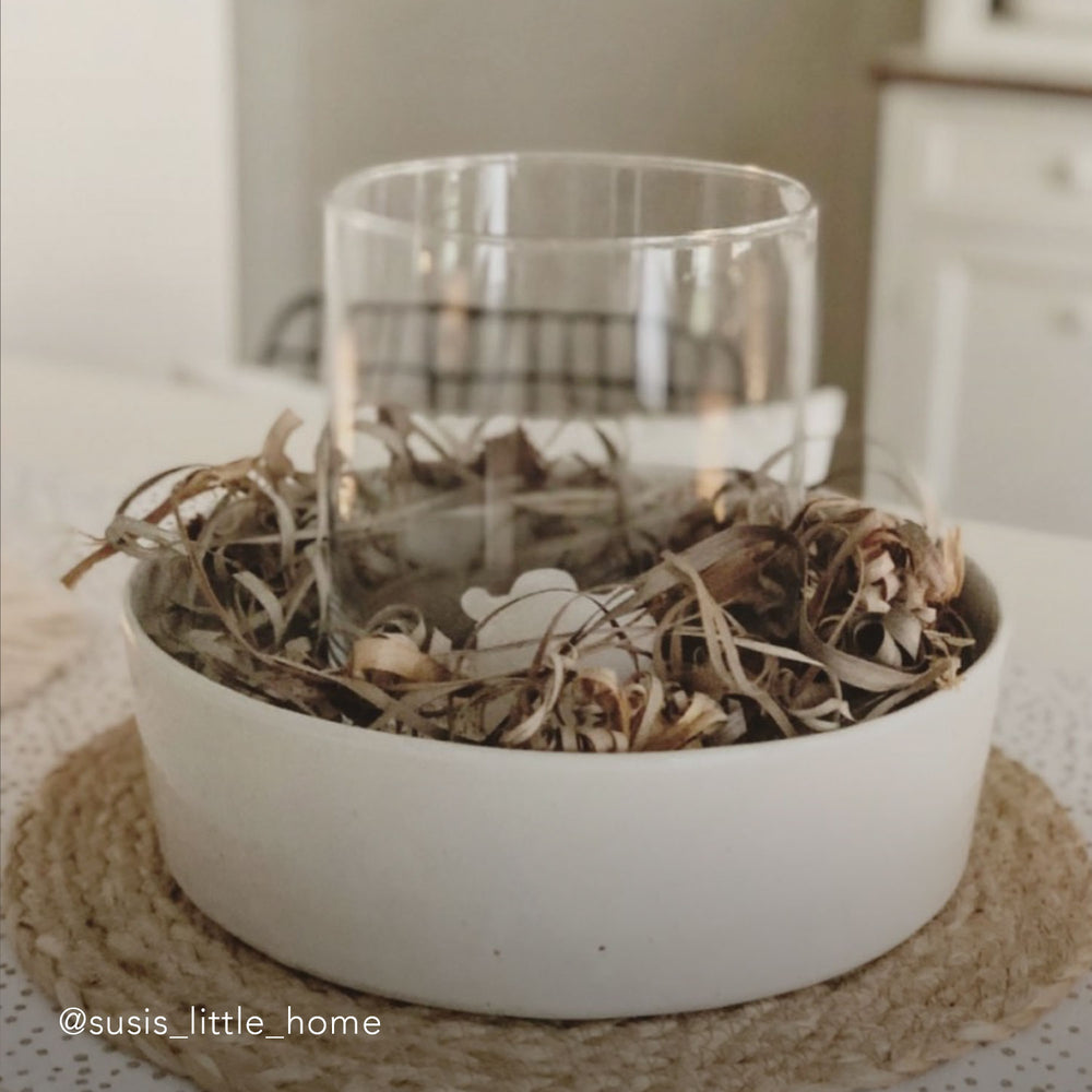 Keramikschale mit hellem Rand, gefüllt mit Dekozweigen und einem Glaszylinder in der Mitte. Die Szene ist in einem gemütlichen Zuhause aufgenommen. Unten links steht der Instagram-Name: @susi_little_home.